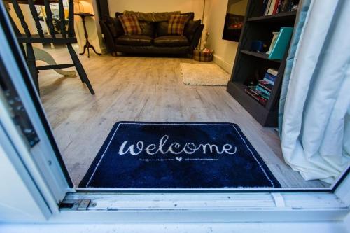 a welcome mat on the floor in a living room at Oakley Country Retreat-1 Bed-Garden-Free Parking in Baddiley