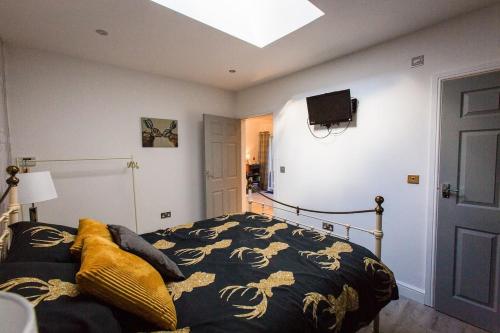 a bedroom with a bed and a tv on the wall at Oakley Country Retreat-1 Bed-Garden-Free Parking in Baddiley