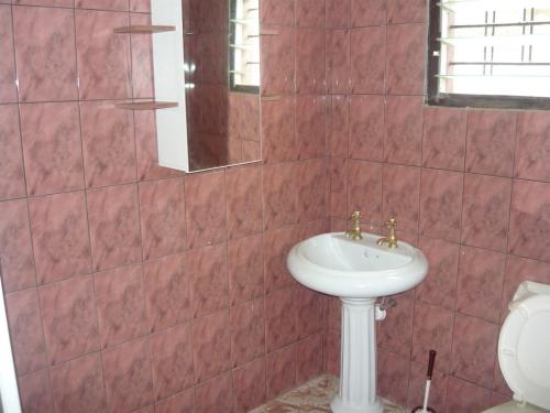 a bathroom with a sink and a toilet at A Spacious 3 Bedroom House in Kumasi