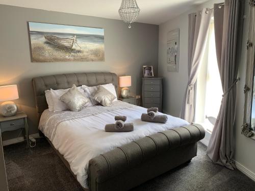 ein Schlafzimmer mit einem Bett mit zwei Teddybären darauf in der Unterkunft Harbour View luxury comfortable Holiday Apartment in Donaghadee