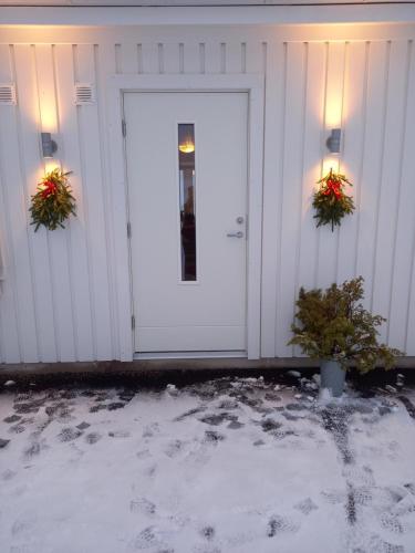 a white garage with two potted plants on it at Mysig lägenhet med fjällutsikt i Sälen in Sälen