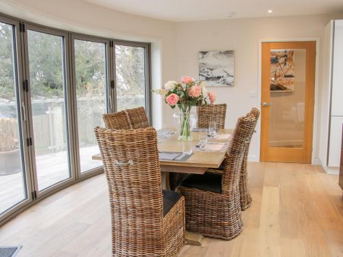 a dining room with a table with wicker chairs at Round House in Church Stretton