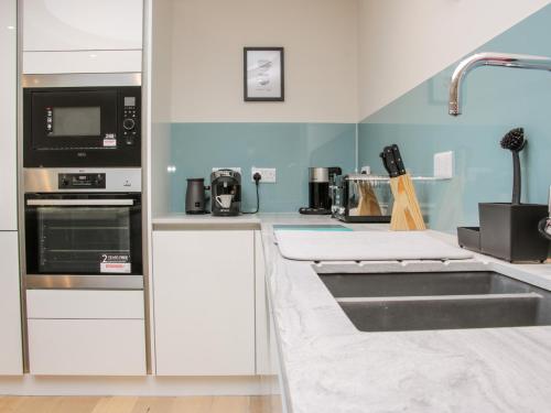 a kitchen with a sink and a microwave at Round House in Church Stretton