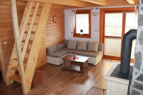 a living room with a couch and stairs in a cabin at Drevenica Trnovec in Liptovský Trnovec