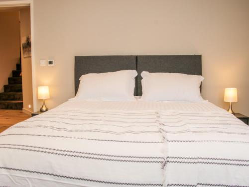a bedroom with a large white bed with two lamps at Round House in Church Stretton