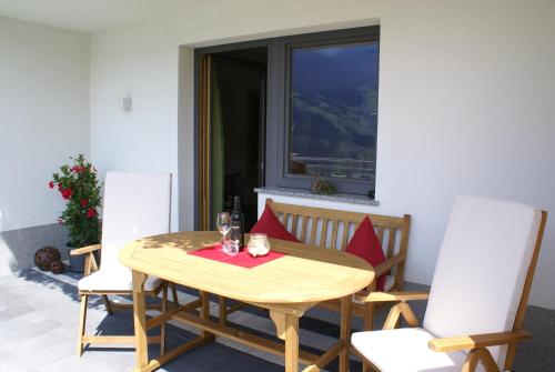 einen Holztisch und Stühle in einem Zimmer mit Fenster in der Unterkunft Apart Spitaler in Gerlosberg