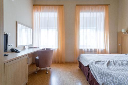 
a hotel room with a bed and a desk at Herzen House in Saint Petersburg
