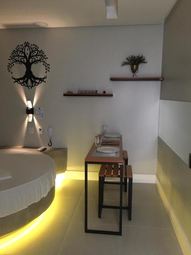 a bedroom with a bed and a table with a table at Absolut Confort Suites in Atalaia Velha