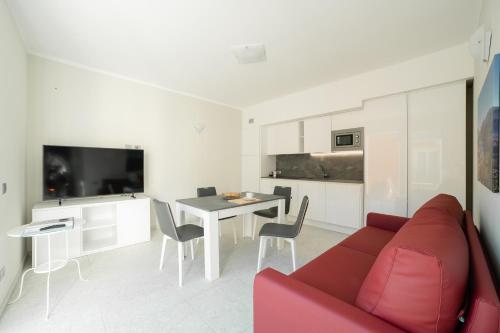 a living room with a red couch and a table at Yachting Residence in Lavena Ponte Tresa