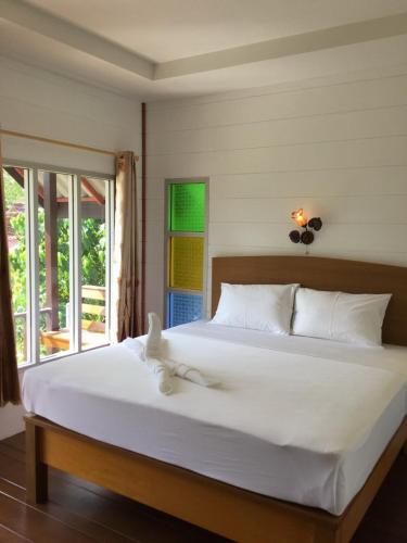 a bedroom with a large bed with white sheets at Lanta Andaleaf Bungalow - SHA Extra Plus in Ko Lanta