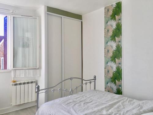 - une chambre avec un lit et un papier peint floral dans l'établissement Respire le Bien-être, à Rosny-sous-Bois