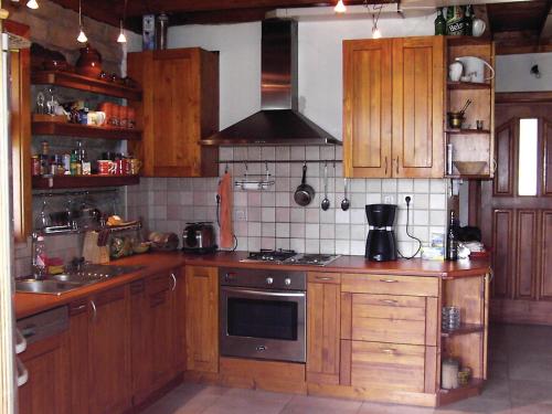 a kitchen with wooden cabinets and a stove top oven at Zhivka House in Glavatartsi