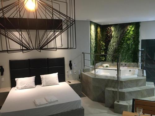 a bedroom with a bathtub and a bed and a bath tub at Absolut Confort Suites in Atalaia Velha