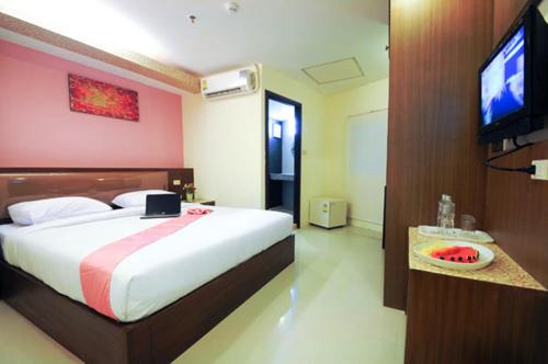 a bedroom with a large bed and a flat screen tv at Royal Express Inn in Bangkok