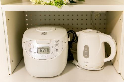 a toaster and a coffee maker sitting on a shelf at Awaji egaosakuie in Sumoto in Sumoto