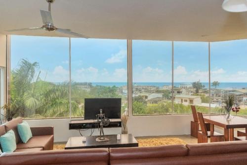 a living room with a couch and a large window at ME Hotel & Villas - Montañita Estates in Montañita