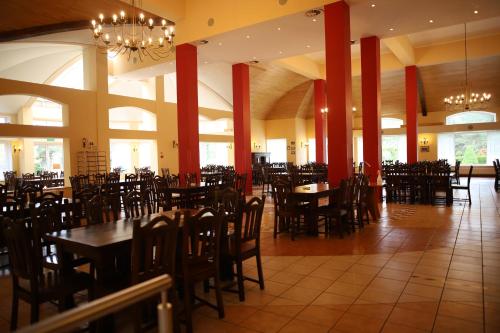 a dining room with tables and chairs in a restaurant at Dom Pielgrzyma ARKA in Licheń Stary