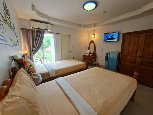 a hotel room with two beds and a window at Euro Boutique Hotel in Chumphon
