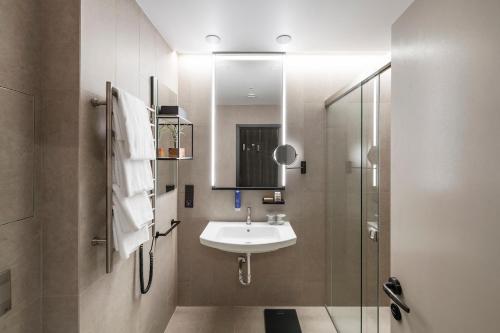 
a bathroom with a sink, toilet and mirror at Amberton Green SPA Druskininkai in Druskininkai
