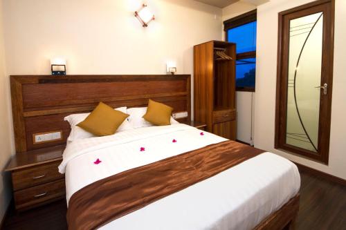 a bedroom with a large bed and a mirror at Tropic Tree Maldives in Gulhi
