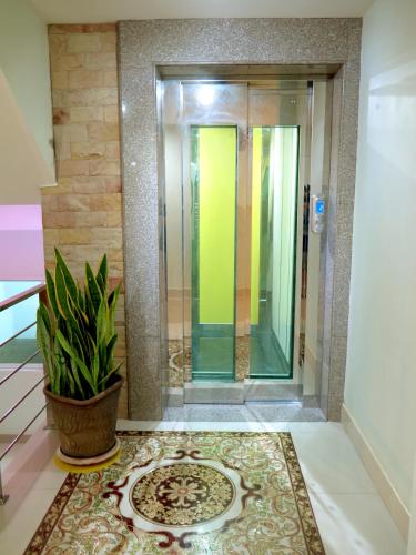 a glass elevator in a lobby with a potted plant at Euro Boutique Hotel in Chumphon