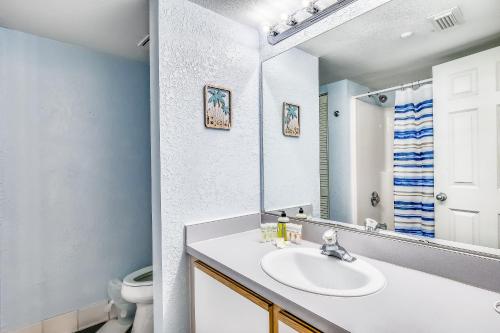 a bathroom with a sink and a toilet and a mirror at Sunrise Suites - Sea Breeze Suite 101 in Key West