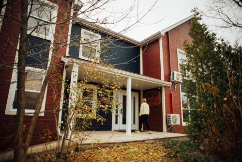 a person standing on the porch of a house at Maison de Vébron in LʼAnse-Saint-Jean