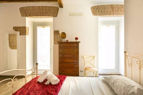 a bedroom with a bed and a dresser and two windows at Pellegrino 75 Actual in Rome