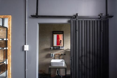 a bathroom with a sink and a shower door at Lilian Lofts Hotel & Spa in Johannesburg