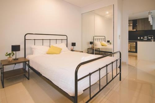 sypialnia z łóżkiem, stołem i lustrem w obiekcie ZEN CENTRAL CBD - Affordable 3-Bdrm Apt in the Heart of Darwin City w mieście Darwin