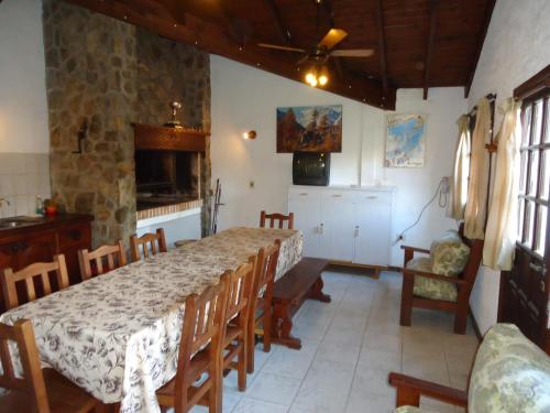 una sala da pranzo con tavolo, sedie e parete in pietra di Apart Rose Garden a San Martín de los Andes