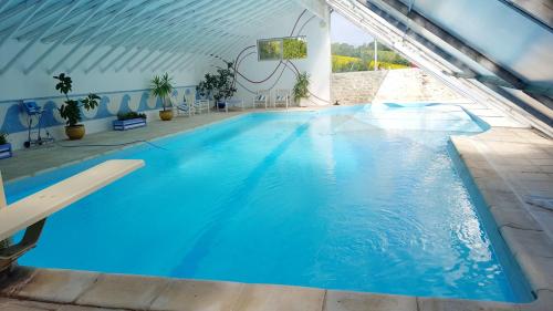une grande piscine bleue dans un immeuble dans l'établissement Villa spacieuse à Crastes avec piscine privée et vue montagne, à Crastes
