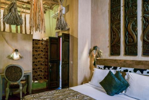 a bedroom with a bed and a table and a chair at 6 bedrooms villa with private pool jacuzzi and furnished terrace at Marrakech in Marrakesh