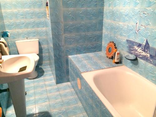 a blue tiled bathroom with a tub and a sink at Maison de charme à La Ciotat + Jardin in La Ciotat