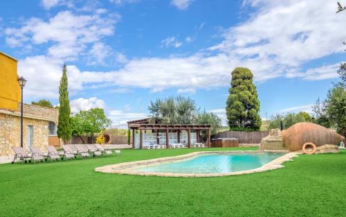 un jardín con piscina y cenador en 9 bedrooms villa with private pool jacuzzi and enclosed garden at Can Trabal, en Can Trabal