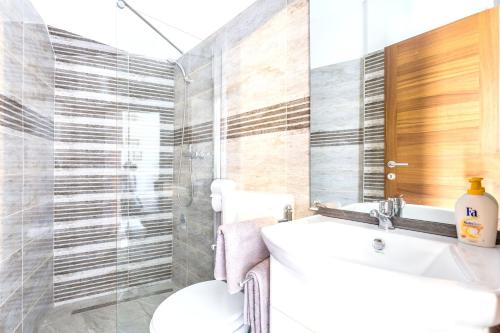 Un baño con un lavabo blanco y un inodoro. en Elegant Villa Bakar sea view, en Bakar