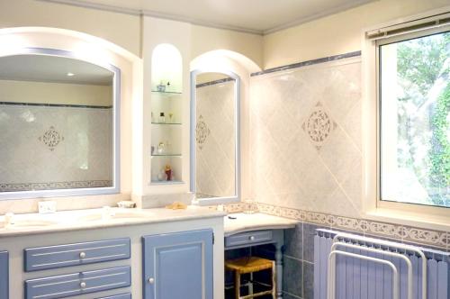 une salle de bain avec deux lavabos et deux miroirs dans l'établissement Villa spacieuse à Vaison-la-Romaine avec piscine privée, à Vaison-la-Romaine