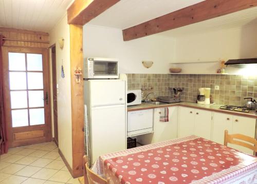 アンブランにあるAppartement de 2 chambres avec wifi a Embrun a 2 km de la plageのキッチン(テーブル、白い冷蔵庫付)
