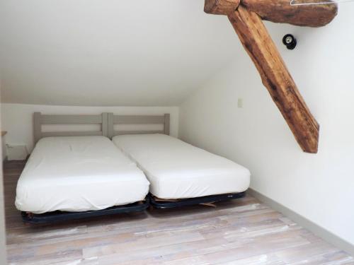 - 2 lits dans une chambre avec une croix sur le mur dans l'établissement Appartement cosy Embrun 40m² + AC, à Embrun