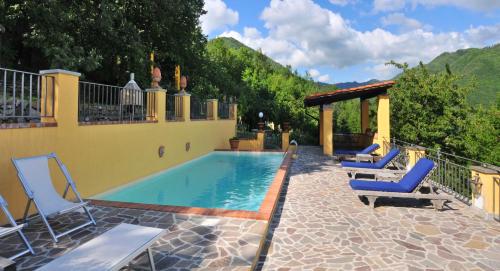 a swimming pool with two chairs and a gazebo at 2 bedrooms house with shared pool enclosed garden and wifi at Gattaia in Gattaia