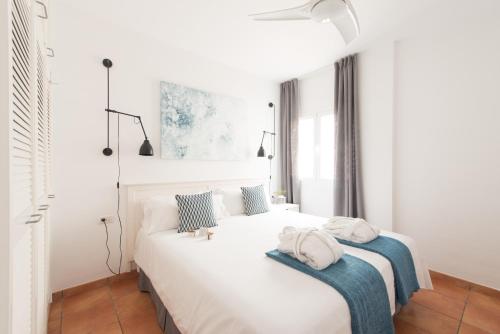 - une chambre blanche dotée d'un lit avec des oreillers bleus et blancs dans l'établissement AD Alberto Dorner - Modern, à Icod de los Vinos