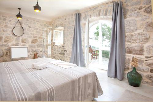 a bedroom with a bed and a large window at Elegant villa in Podgora with private pool and sea view in Podgora