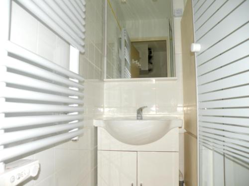 een witte badkamer met een wastafel en een spiegel bij Studio accueillant aux Deux Alpes de 21 m² avec vue montagne in Les Deux Alpes