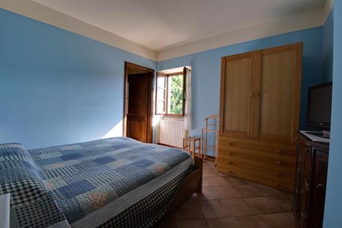 a bedroom with blue walls and a bed and a television at 3 bedrooms house with furnished terrace and wifi at Castelnuovo di Garfagnana in Castelnuovo di Garfagnana