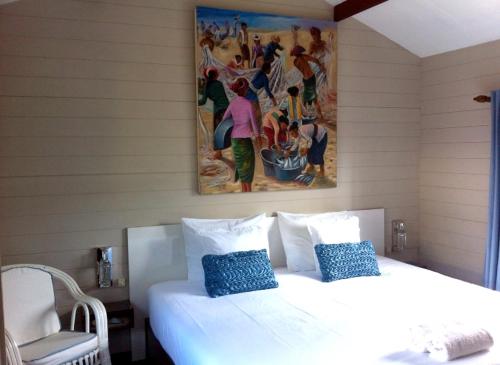 a bedroom with a white bed and a painting on the wall at Charming House in Albion with Shared Pool in Albion