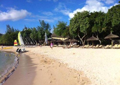 a beach with chairs and umbrellas and the ocean at Charming House in Albion with Shared Pool in Albion