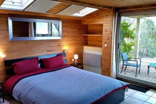 1 dormitorio con cama y ventana grande en Studio 32m2 - dans propriété avec vue imprenable sur le Lac du Salagou, en Liausson