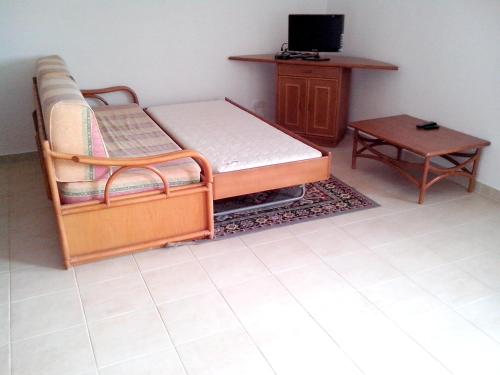 1 dormitorio con cama, mesa y TV en One bedroom apartement with shared pool enclosed garden and wifi at Albufeira 2 km away from the beach, en Albufeira
