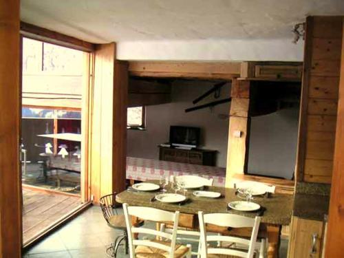 a dining room with a table and chairs and a kitchen at Chalet de 5 chambres avec jardin amenage et wifi a Sainte Foy Tarentaise a 1 km des pistes in Sainte-Foy-Tarentaise