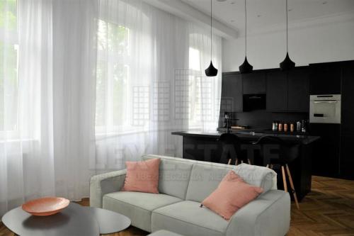 ein Wohnzimmer mit einem weißen Sofa und einem Tisch in der Unterkunft 1-Bed Apartment in Zabrze 15 min Katowice Gliwice in Zabrze